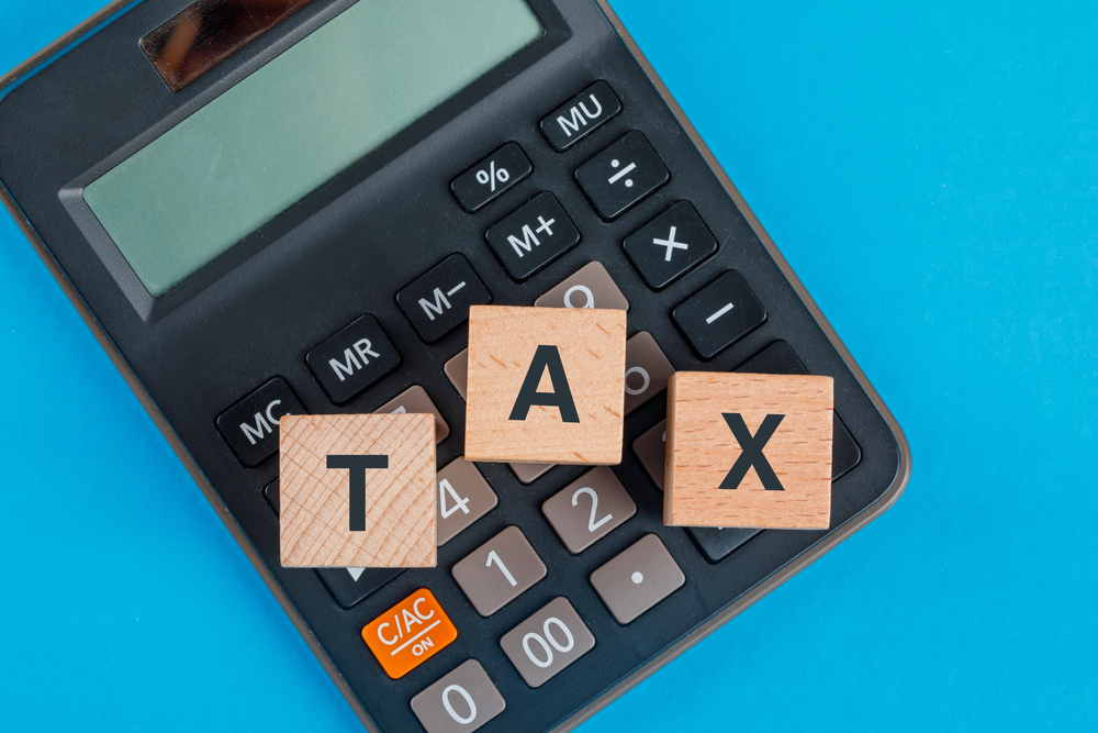 tax-planning-concept-with-wooden-cubes-calculator-blue-table-flat-lay-1.jpg